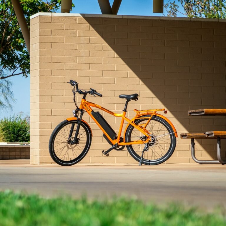 red-and-black-city-bike-parked-beside-brown-concrete-building-during-daytime
